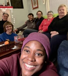Diverse group of smiling folks in a cozy living room.