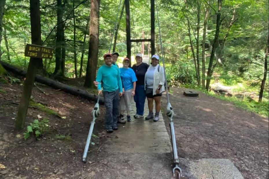 A group of people standing on a trail in the woods